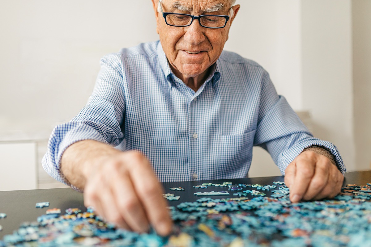 Elderly Man doing a puzzle